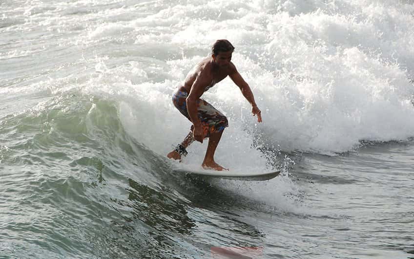 Ein Surfer reitet auf den Wellen in Manuel Antonio