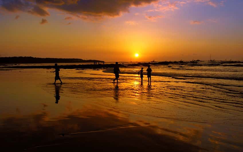 People on Tamarindo beach enjoying a beautiful sunset.