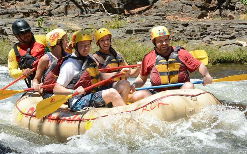 Eine Gruppe von Menschen, die eine Wildwasser-Rafting-Tour auf dem Fluss genießen.