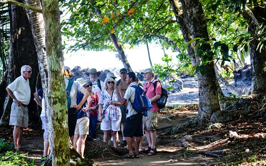 Eine Gruppe älterer Menschen bei einer geführten Tour durch den Nationalpark Manuel Antonio mit einem örtlichen Reiseleiter