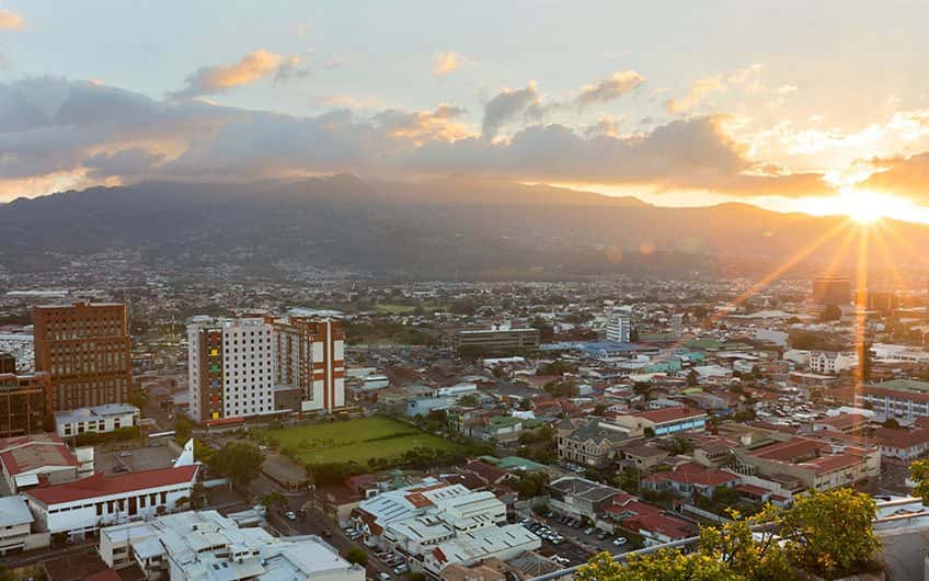 Das Wetter in San Jose Costa Rica kann je nach Tageszeit variieren. Auf dem Bild ist der Sonnenuntergang der Stadt von oben zu sehen.